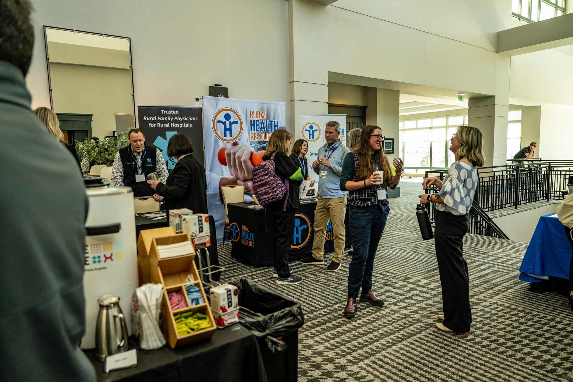 Attendees talk and laugh at exhibitor booths at The Colorado Rural Healthcare Conference.